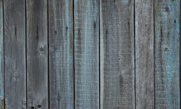 Wooden texture. Old wooden fence near house. Old and dry boards. Gray wooden background.