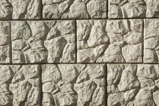 An old stone wall in close-up in a soft light color scheme. Stone tile background with detailed natural texture.