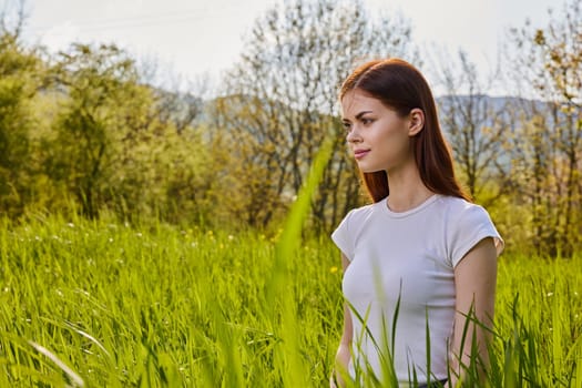 portrait of a pensive woman sitting in the grass in nature. High quality photo
