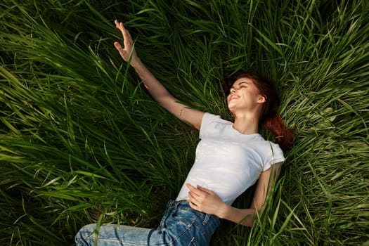 happy peaceful woman lies in the park on high grass. High quality photo