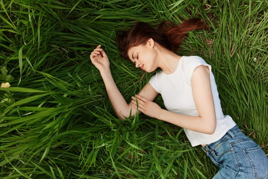 a peaceful woman lies in the grass enjoying the unity with nature. High quality photo
