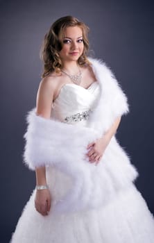 Image of attractive young bride on gray background