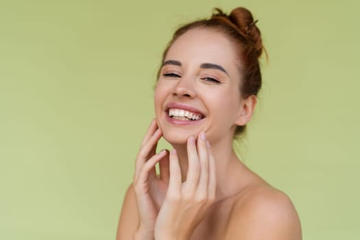 Beauty portrait of young topless red hair woman with bare shoulders on green background with perfect skin and natural makeup