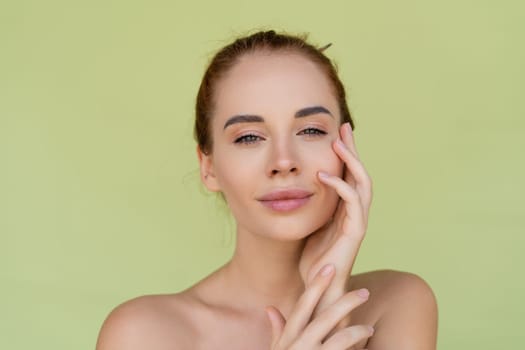 Beauty portrait of young topless red hair woman with bare shoulders on green background with perfect skin and natural makeup