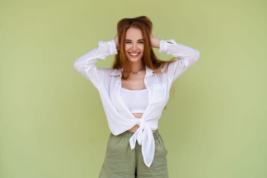 Beautiful long red hair woman in casual shirt on green background positive smiling laughing enjoying exited