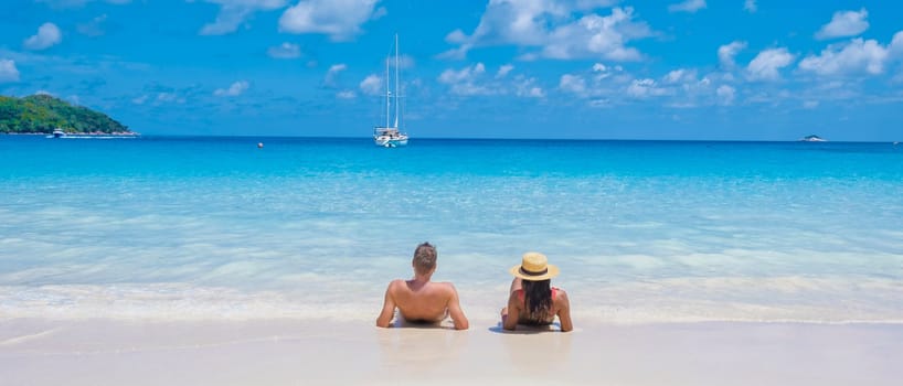 Anse Lazio Praslin Seychelles, a young couple of men and women on a tropical beach during a luxury vacation in Seychelles. Tropical beach Anse Lazio Praslin Seychelles