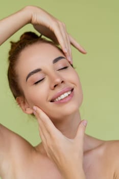 Beauty portrait of young topless red hair woman with bare shoulders on green background with perfect skin and natural makeup