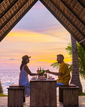 Romantic dinner on the beach with Thai food during sunset on the Island of Koh Mak Thailand. Couple of men and women having a romantic dinner on the beach