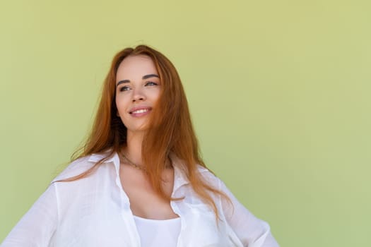 Beautiful long red hair woman in casual shirt on green background positive smiling laughing enjoying exited