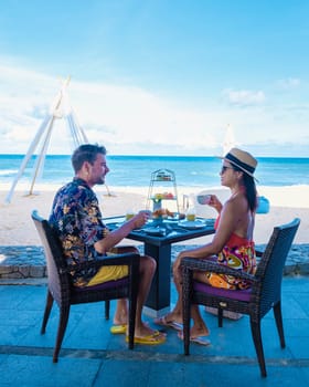 Breakfast on the beach in Phuket Thailand, a couple of men, and women having a Luxury breakfast table with food and beautiful tropical sea view background., luxury travel and lifestyle honeymoon