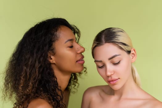 Woman close beauty portrait mixed race black skin and white skin, two female on green background