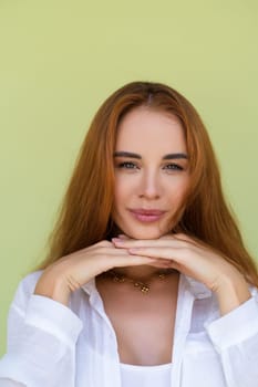 Beautiful long red hair woman in casual shirt on green background positive smiling laughing enjoying exited