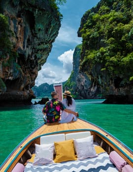 Luxury Longtail boat in Krabi Thailand, couple man, and woman on a trip at the tropical island 4 Island trip in Krabi Thailand. Asian woman and European man mid age on vacation in Thailand.