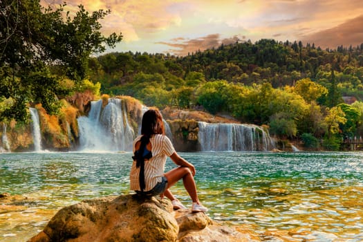KRK waterfalls, woman watching sunset at the waterfall Croatia Krk national park Croatia