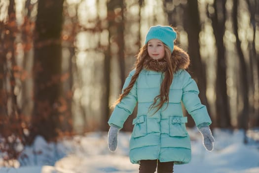 girl in turquoise clothes in a snowy forest