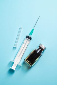 Transparent plastic syringe on blue background with empty copy space