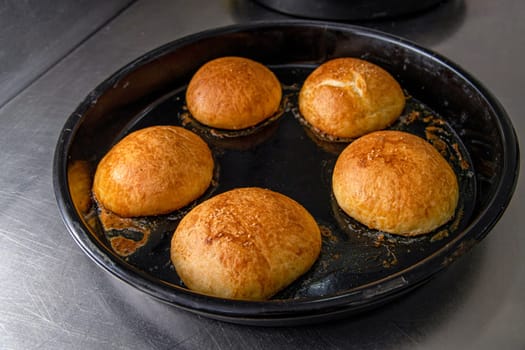 Freshly baked hot burger buns in an industrial oven