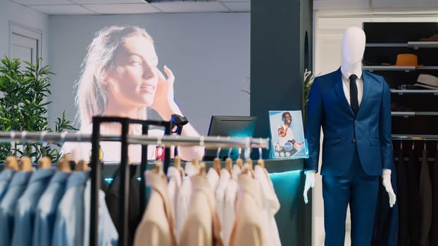 Interior of fashionable store with clothes on racks, stylish brand design and formal wear in retail market boutique. Empty clothing showroom in shopping center with merchandise, commercial activity.