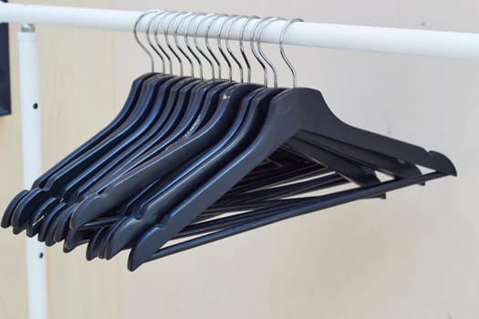 Wooden hangers for clothes hang on the rail. Order and storage of things. Comfort and cleanliness in the house.