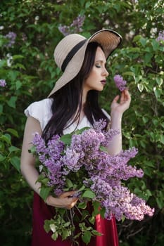 A fashionable girl with dark hair, a spring portrait in lilac tones in summer. Bright professional makeup