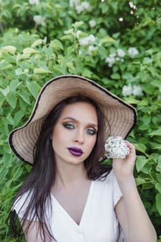 A fashionable girl with dark hair, a spring portrait in lilac tones in summer. Bright professional makeup