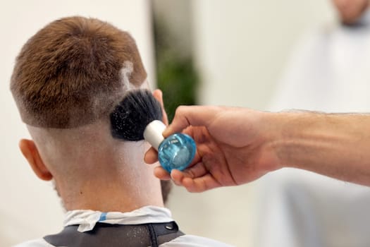 barber holding brush for talco in barber shop. close-up