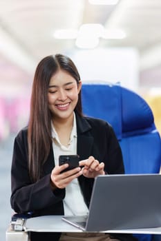 Beautiful Asian business woman chatting with client by mobile phone during flight. working, travel, business concept.