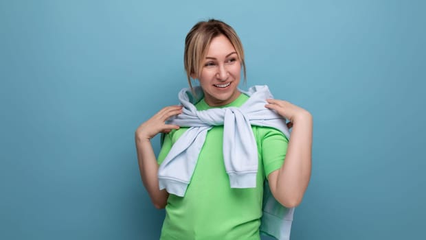 banner portrait of a positive bright girl in a casual outfit on a blue background with copy space.