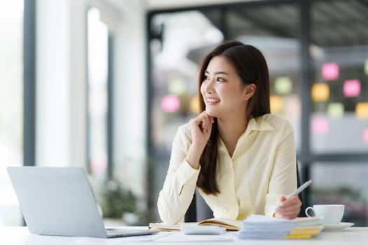 Beautiful Asian Banker or Accountant makes financial report and tax, analyzes profits. Accountant checks status of financial.