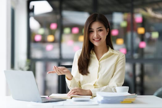 Beautiful Asian Banker or Accountant makes financial report and tax, analyzes profits. Accountant checks status of financial.