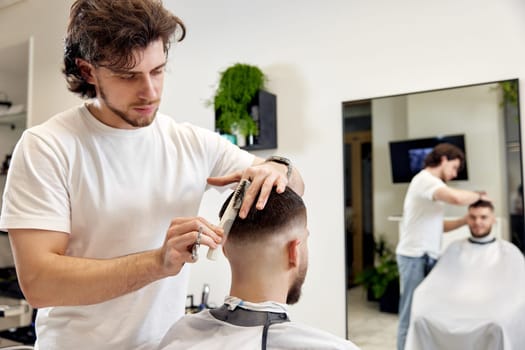 hairdresser does haircut for caucasian bearded man using comb and grooming scissors in barber shop.