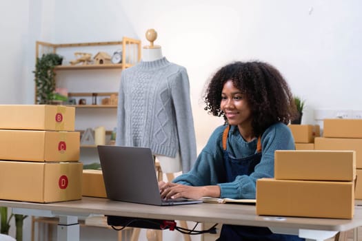 Young woman freelancer sme business online shopping look at camera with cardboard box on table at home - Business online shipping and delivery concept..