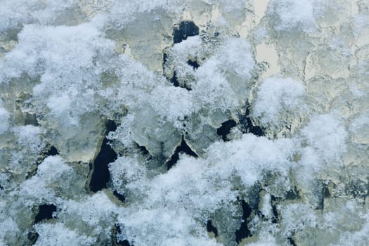 Image of melting snow on the glass of a large window.