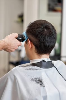 Barber shaving handsome caucasian man in barber shop.