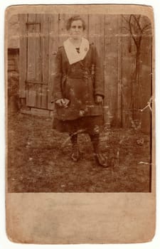 THE CZECHOSLOVAK REPUBLIC - CIRCA 1930s: Vintage photo shows rural woman poses outside. Retro black and white photography with sepia effect.