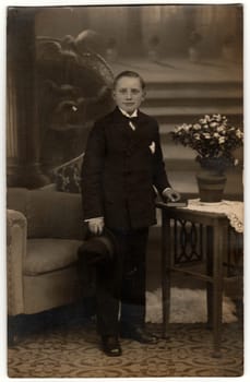 PRAGUE, THE CZECHOSLOVAK REPUBLIC - CIRCA 1920s: Vintage photo shows man poses in an elegant room. Black and white photography with sepia effect.