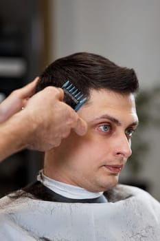 Barber shaving handsome caucasian man in barber shop.