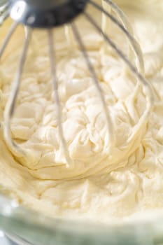 Whipping white ganache in kitchen mixer to make the white chocolate ganache frosting.