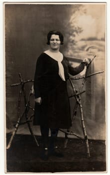 GERMANY - CIRCA 1930s: Vintage photo shows woman in a photography studio. Retro black and white studio photography with sepia effect.