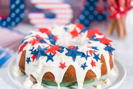 July 4th bundt cake covered with a vanilla glaze and decorated with chocolate stars on a white plate.