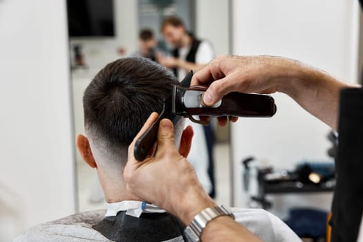 Barber shaving caucasian man in barber shop. close-up