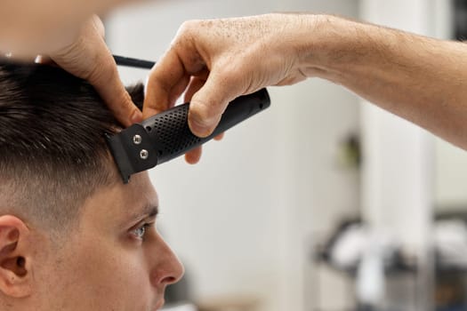Barber shaving caucasian man in barber shop. close-up
