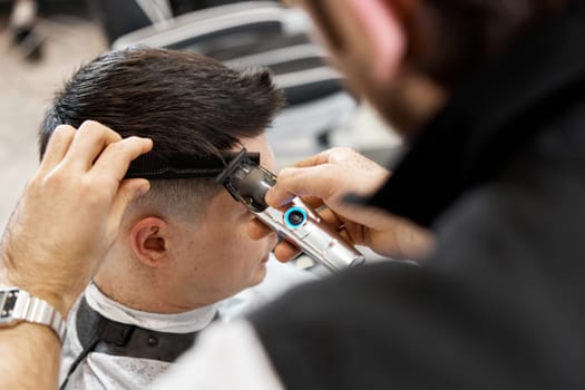 Barber shaving caucasian man in barber shop. close-up
