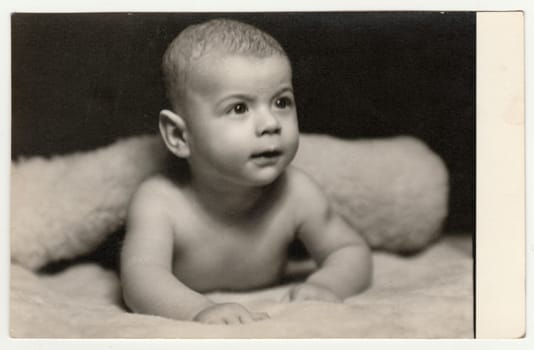 THE CZECHOSLOVAK SOCIALIST REPUBLIC - NOVEMBER 12, 1959: Vintage photo shows baby boy - toddler. Original retro black and white photography taken from photo album. No postprocess