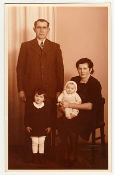RICANY, THE CZECHOSLOVAK REPUBLIC - 1930: Vintage photo shows family in the photography studio. Retro black and white photography with sepia effect.