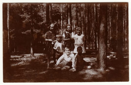 THE CZECHOSLOVAK REPUBLIC - JULY, 1925: Vintage photo shows children in the forest. Retro black and white photography.