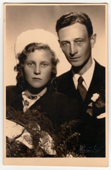 ZLIN, THE CZECHOSLOVAK REPUBLIC - JULY 7, 1944: Vintage photo shows newlyweds. Retro black and white studio photography. Circa 1940s.