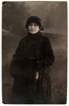 THE CZECHOSLOVAK REPUBLIC - 1919: Vintage photo shows woman wears fur coat and fur muff. Retro black and white studio photography. Circa 1920s.