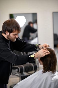 male hairdresser working with client at the beauty salon