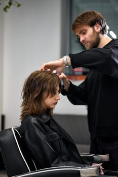 male hairdresser working with client at the beauty salon